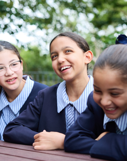 Meriden students laughing together outdoors in school uniform